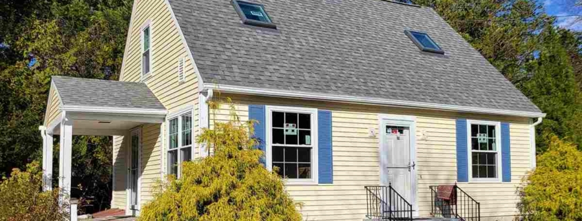 Cape Cod house with yellow siding and blue shutters.