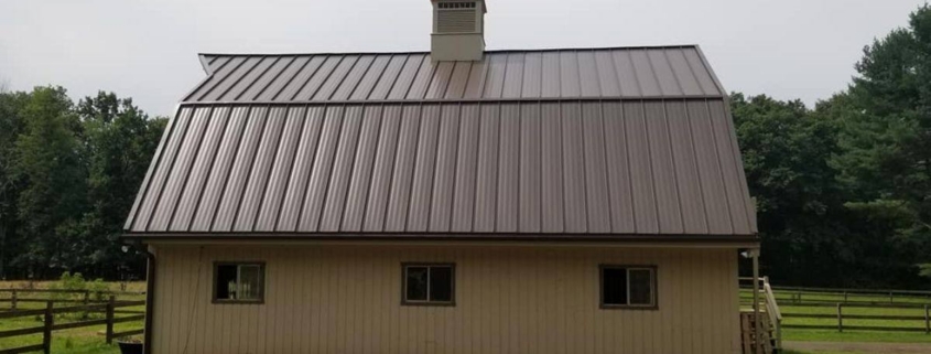 Barn with metal gambrel roof and cupola with weathervane.