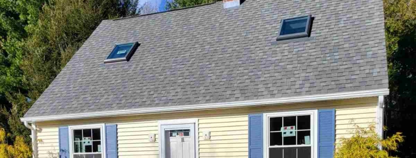 A quaint house featuring a gray roof and blue shutters, set in the community of Deep River.