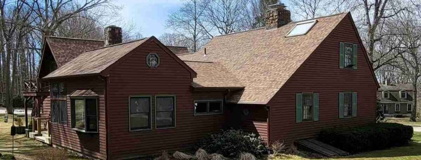 A brown house with a red roof and green trim stands in Deep River.