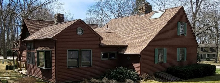 A brown house with a red roof and green trim stands in Deep River.