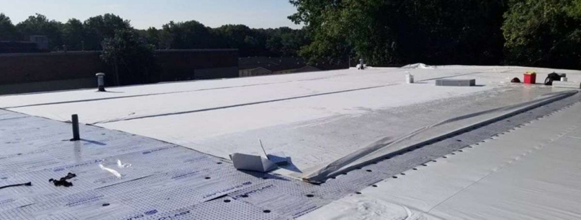 Commercial roof with white membrane installation in progress.