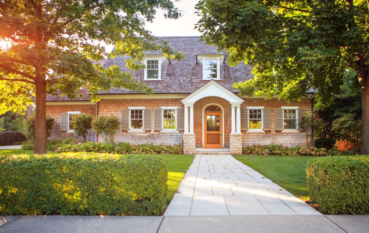 A charming home featuring a welcoming front door and a neatly paved walkway, highlighting roof repair services in Guilford, CT.