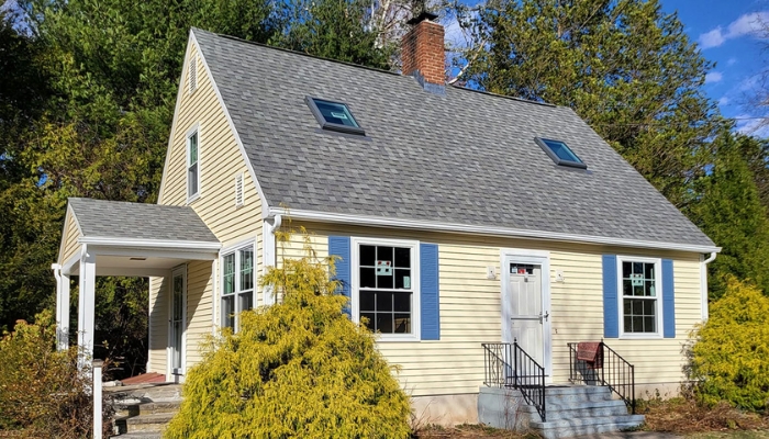 A small house with a porch with well maintained roofing by trusted roofing contractor