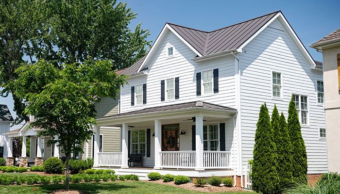 White horizontal siding covering a two-story house exterior with a front porch.