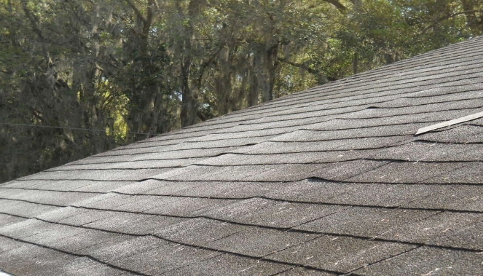 A roof with a missing shingle, highlighting sagging areas, relevant to roof repair versus replacement in Connecticut.