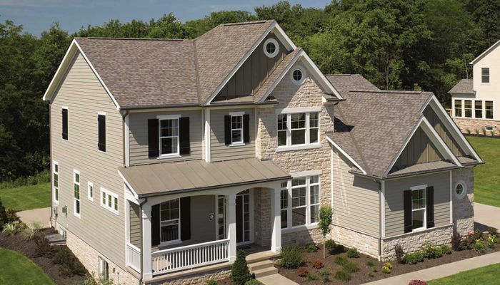 Two-story home with asphalt shingles, featuring a large porch and spacious yard.