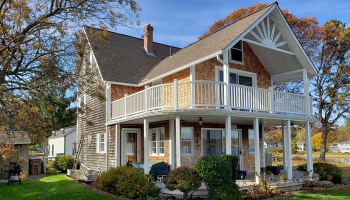 A Craftsman-style house featuring a porch and a balcony, showcasing various types of siding.