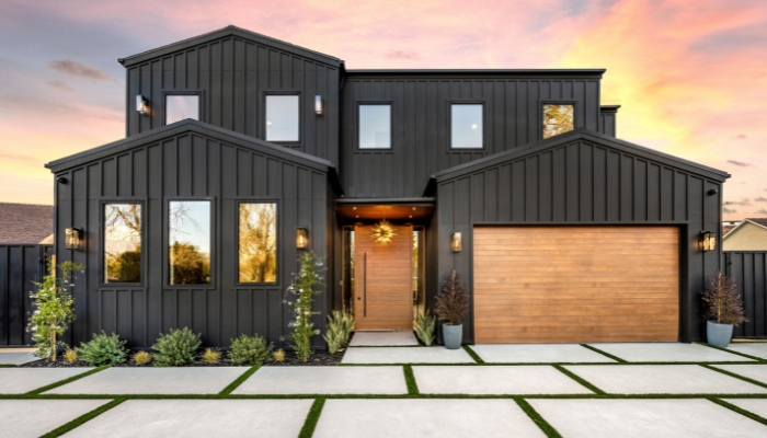 Sleek black residence with a generous garage, designed with metal siding.