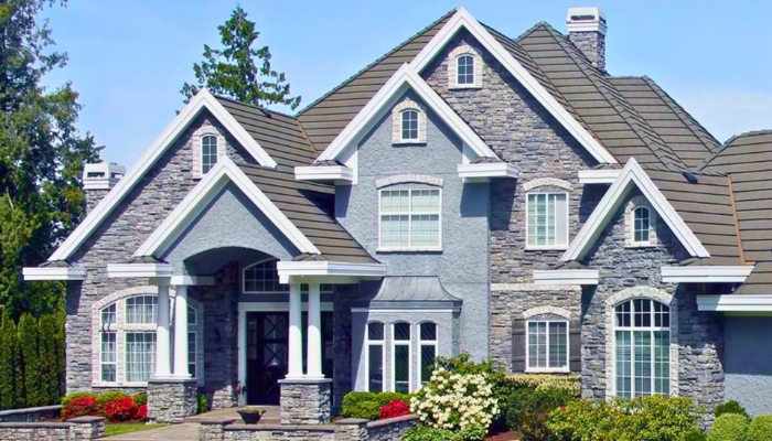 A large house featuring a combination of stone and brick siding, showcasing different types of exterior materials.