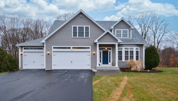 A gray house with a driveway and garage, highlighting the use of Hardie Plank siding for a modern look.