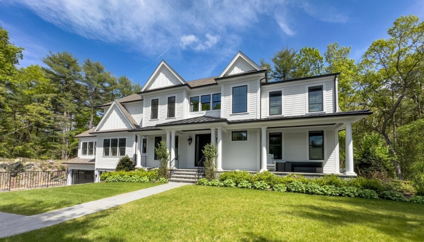 A spacious white house with lush green grass and trees, highlighting the impact of siding on curb appeal and ROI.