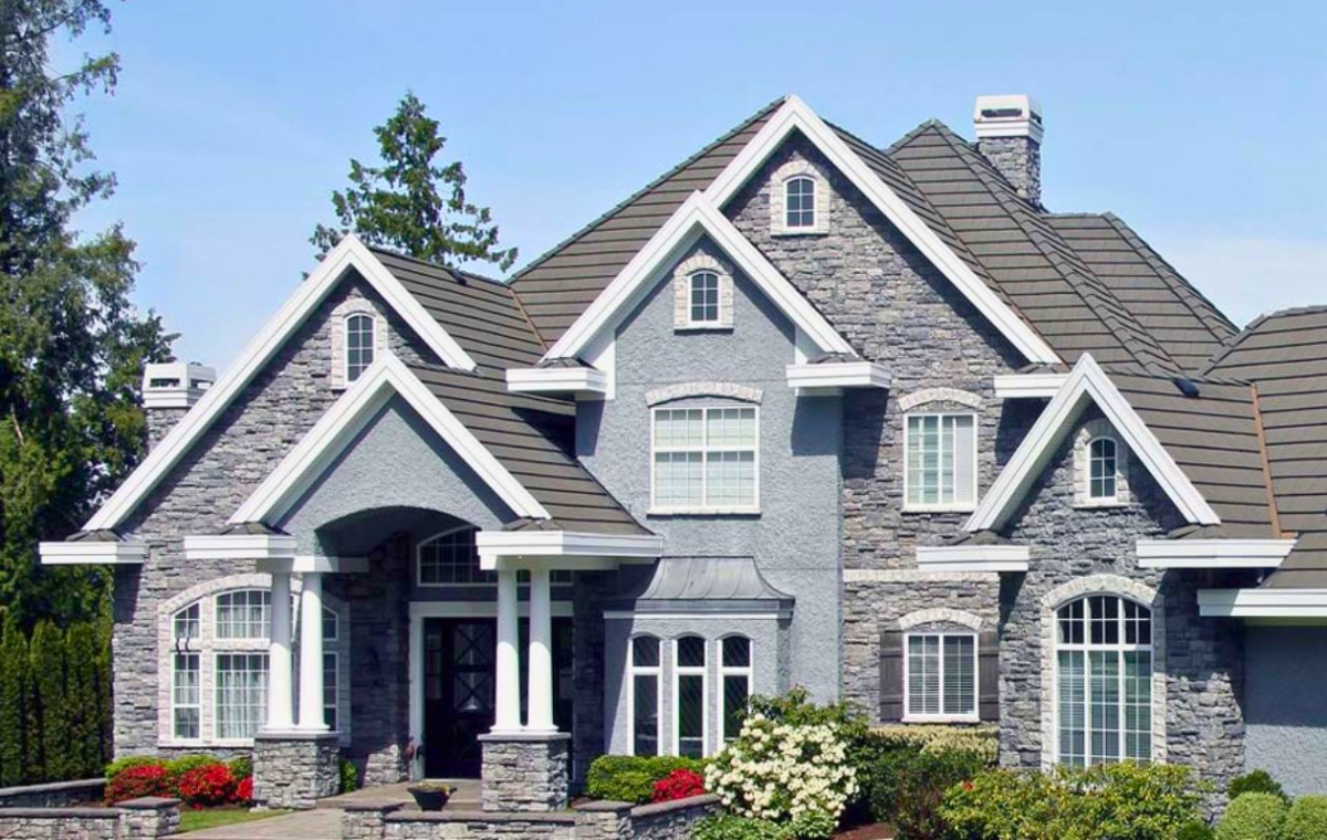 A large residential house featuring a stone and brick exterior, showcasing a blend of traditional architectural styles.