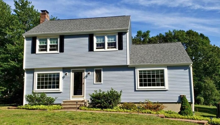 A blue house with black shutters and white trim, demonstrating composite siding design.