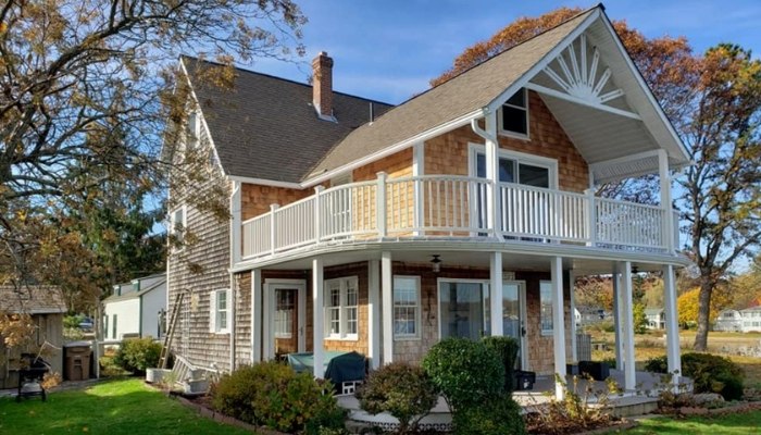 A Craftsman-style house featuring a porch and a balcony, showcasing various types of siding.
