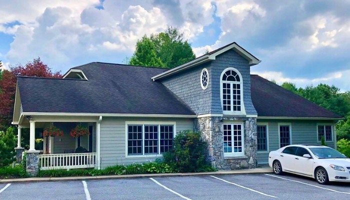 Gray horizontal siding and stone veneer covering a building exterior with shake accents.