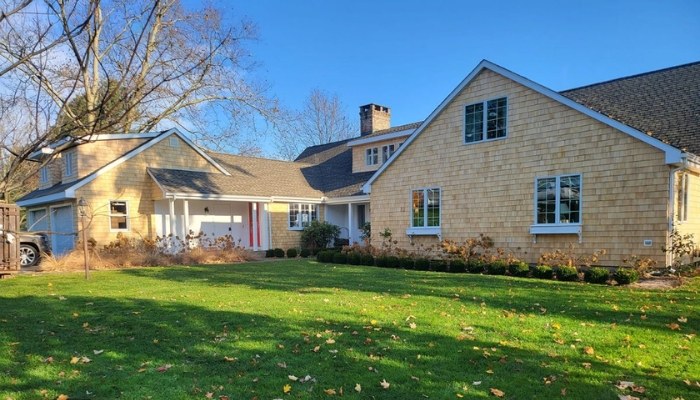 A home with a spacious yard and driveway, showcasing various popular siding styles.