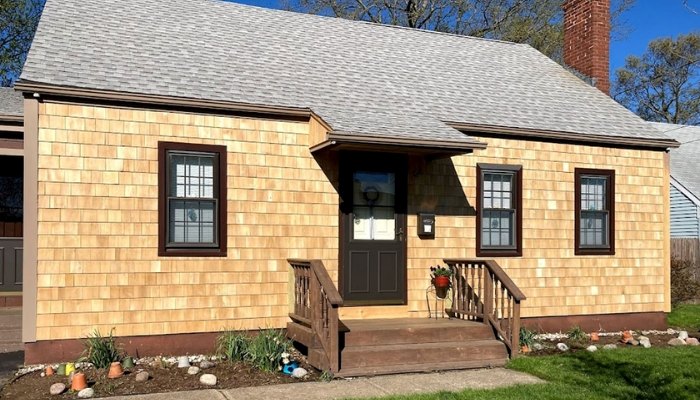 Light wood shake siding covering a small single-story house exterior.