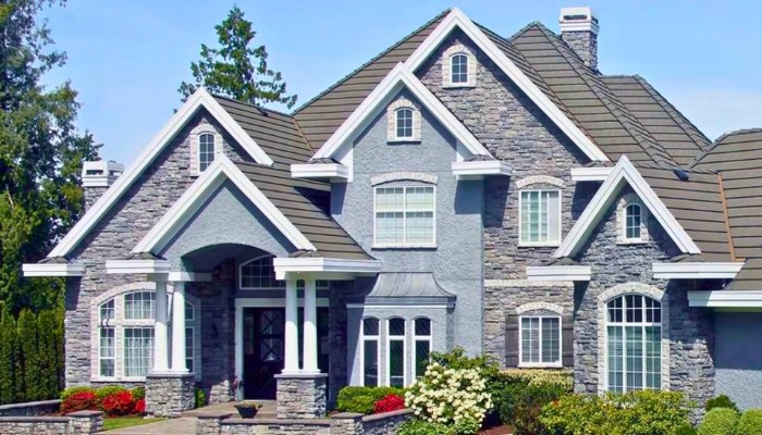 A large house featuring a combination of stone and brick siding, showcasing different types of exterior materials.