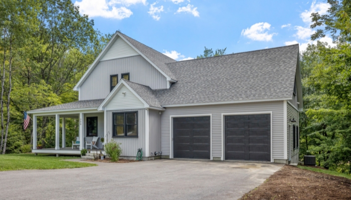 A residential home with a garage and driveway, highlighting the advantages of using composite siding materials.