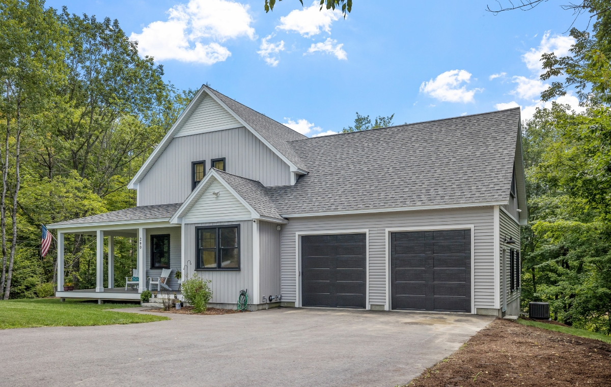A home featuring a garage and driveway, showcasing composite siding, located in Madison, CT.