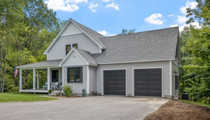 A residential home with a garage and driveway, highlighting the advantages of using composite siding materials.