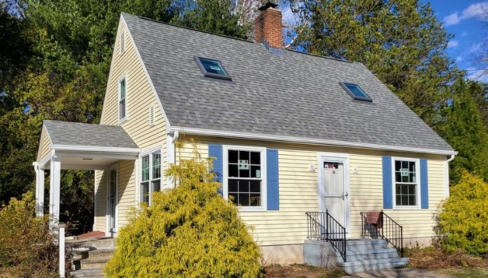 A charming yellow house with blue trim, highlighting the best vinyl siding choices for residential properties.
