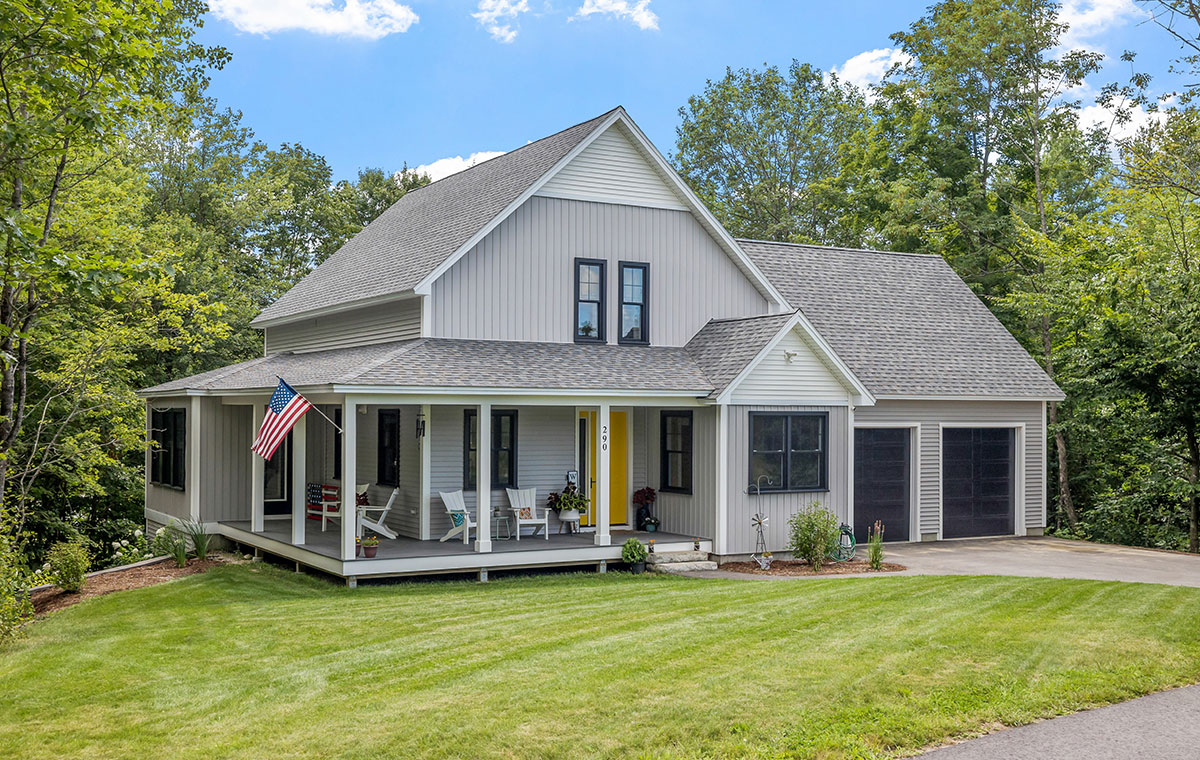 A gray home with black window frames and a covered porch, showcasing Hardie Board siding in Old Lyme, CT.
