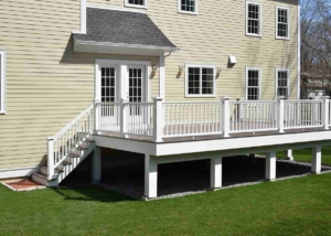 Composite deck with a railing and stairs leading up to the front door, showcasing a welcoming entrance.