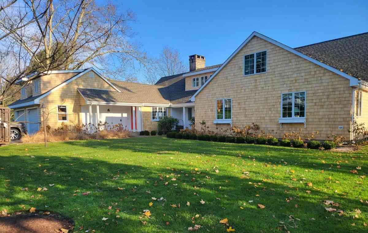 Stonington, CT home with cedar siding, showcasing a spacious yard and wide driveway.