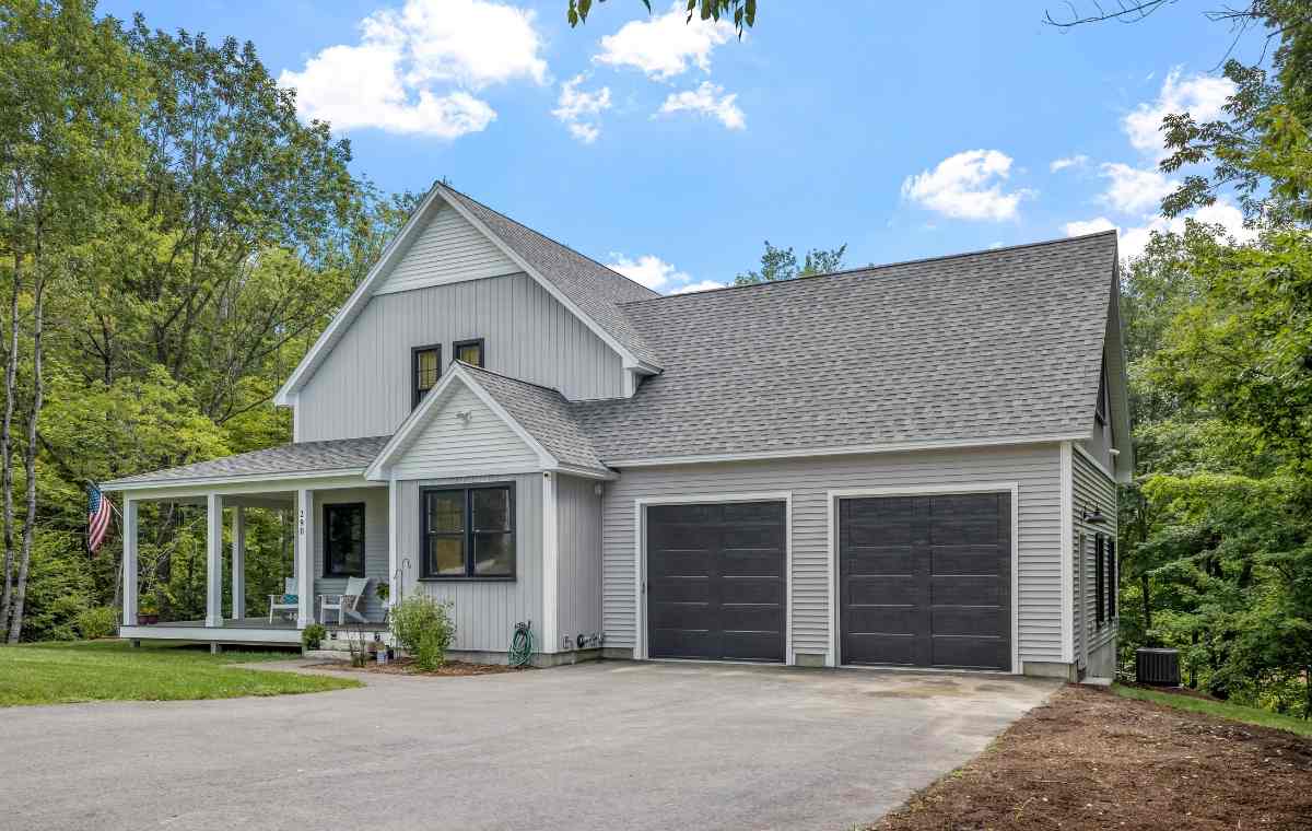 A home featuring a garage and driveway, showcasing composite siding, located in Fairfield, CT.