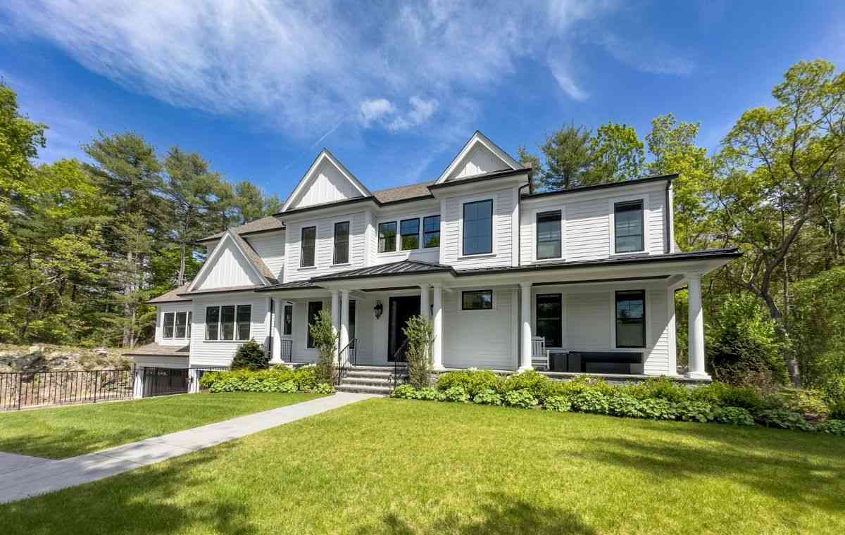 Modern farmhouse with white siding and porch.