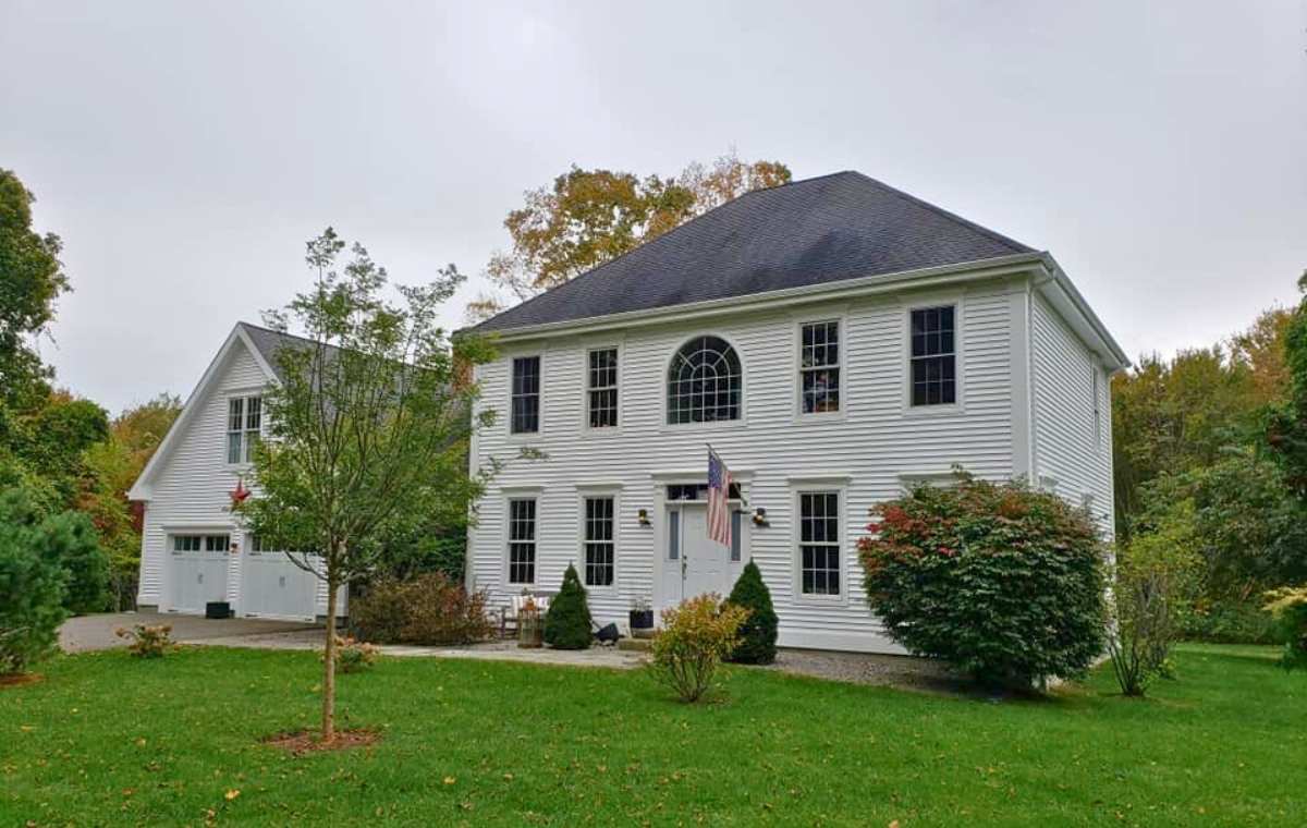 A prominent white house with an expansive yard, showcasing a siding company based in Greenwich, CT.