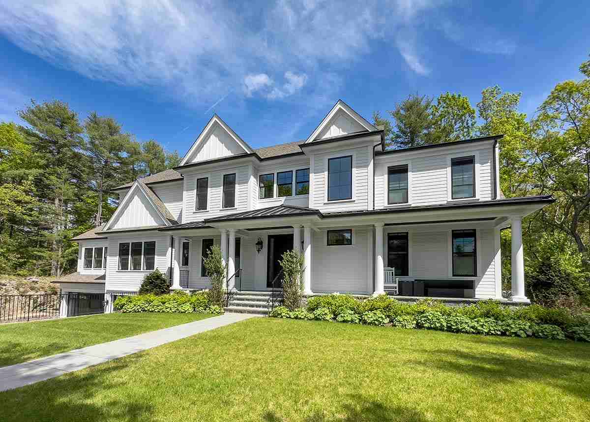 Modern farmhouse with white siding and porch.