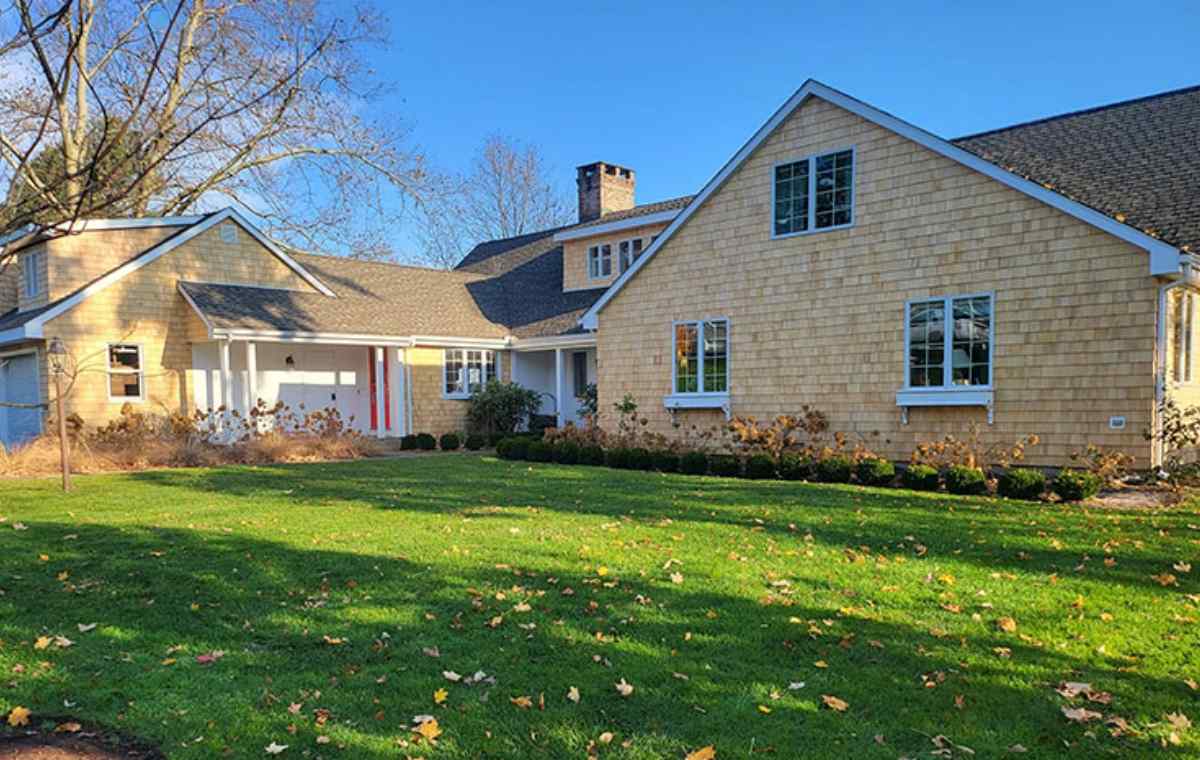 A large home with a spacious yard and driveway, showcasing siding installation in Fairfield, CT.