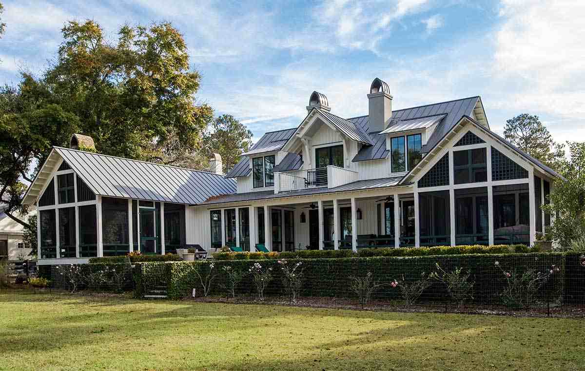 Modern farmhouse with white board-and-batten siding and metal roof.