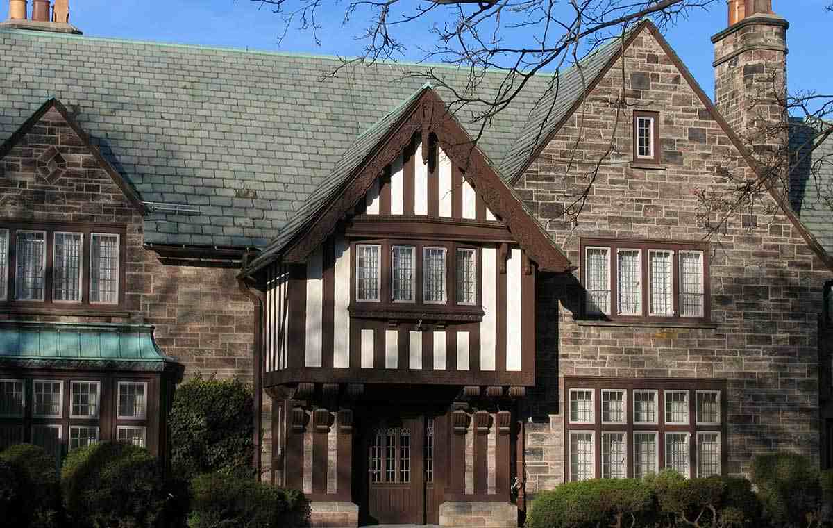 Tudor-style home with stone facade, slate roof, and timbered gable.