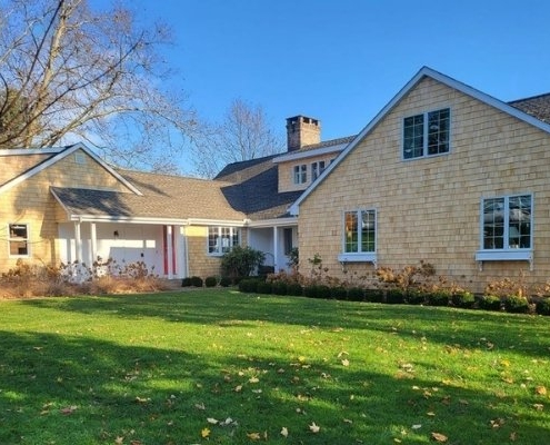 A residence with an expansive yard and large driveway, emphasizing the lasting quality of cedar siding on the exterior.