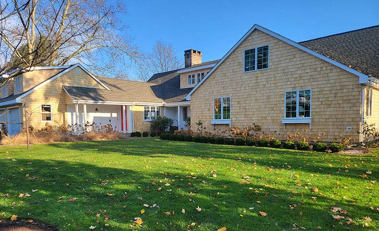 Large home with yard and driveway, roof visible in background.