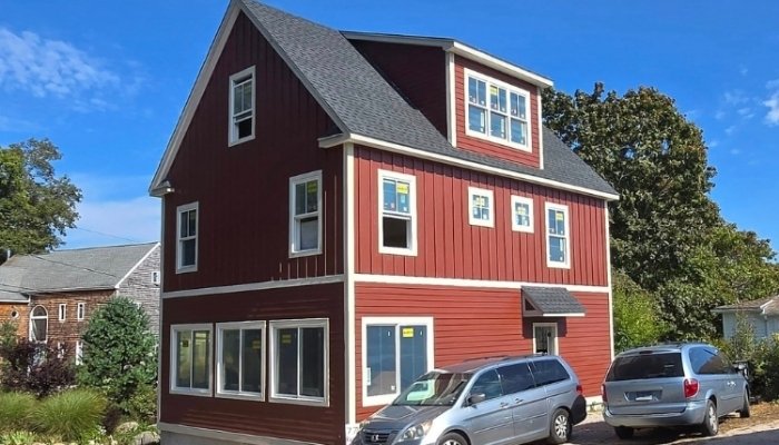 James Hardie siding installation on red two-story home with multiple windows in Guilford CT