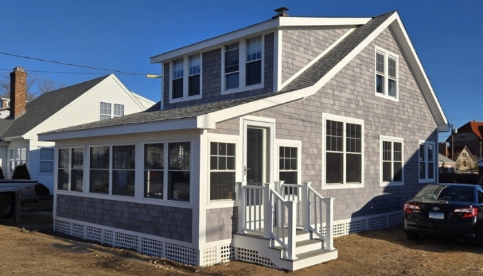Wood siding repair on gray shingle home with porch and dormer comparing repair vs replacement