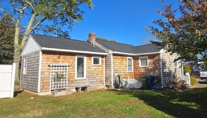 Wood siding repair on weathered cedar shingle home showing signs for replacement decision