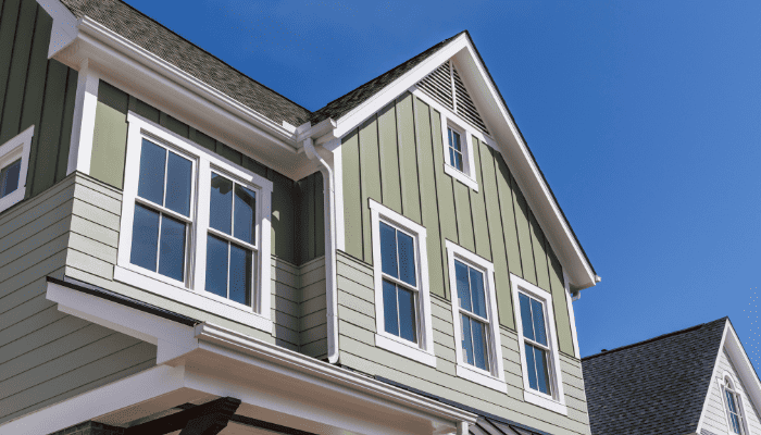 Close-up of a house with green vertical and horizontal siding.
