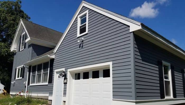 Gray house with white trim, black shutters, and a white garage door.