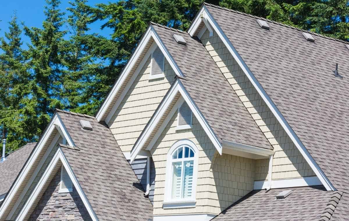 NuCedar siding in CT with cream shingle siding, white trim, and stone accents.